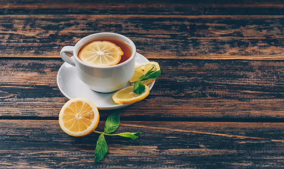 Cup tea with lemon high angle view dark wooden background space text