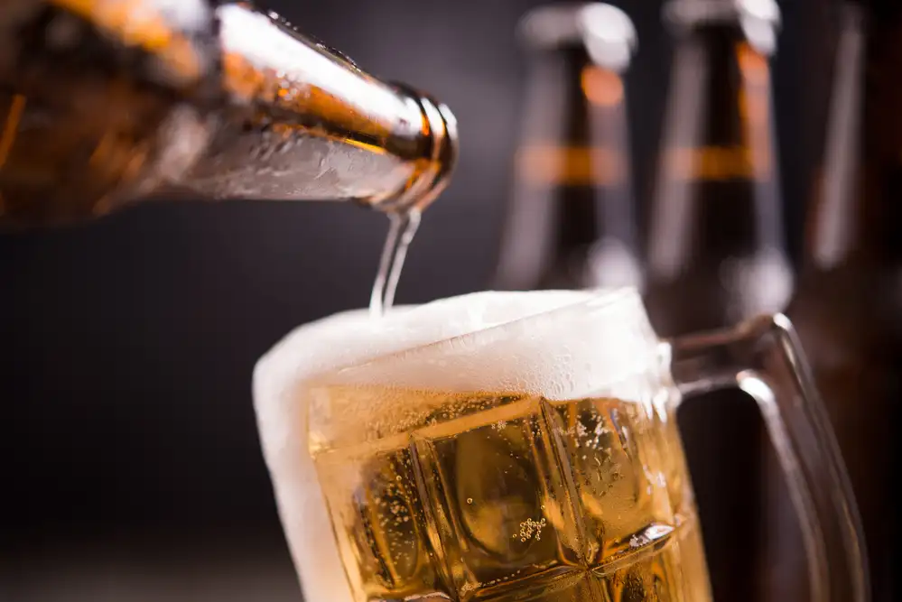 Glass bottles beer with glass ice dark background
